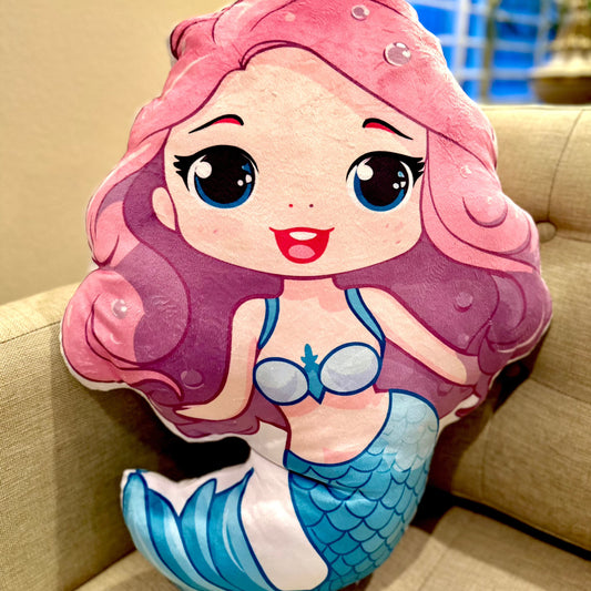 Suzie mermaid girl is wearing a light blue skirt/tail and top - pink long swingy hair and blue big sweet eyes - a cuddle-buddy pillow doll in 4 sizes up to 28 inches tall - minky soft and comforting to cuddle - small is perfect for traveling as a comfort-buddy that will start conversations yes! So fun!